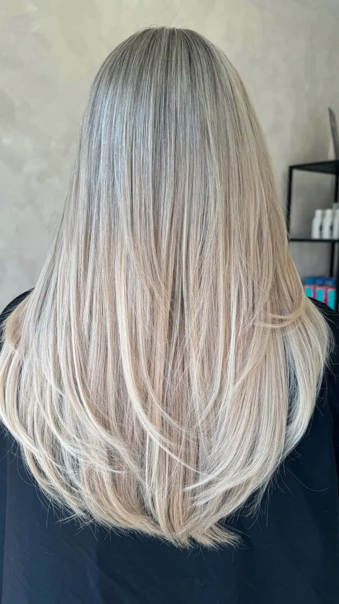 Long, layered blonde hair with tape extensions, seen from behind, finished at Crown Perfect hair salon in Worcester Park, Surrey