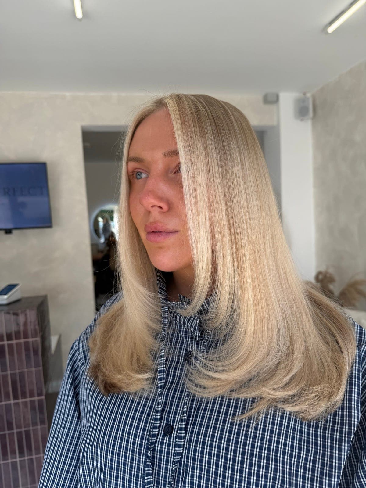 Long, cool-toned blonde worn sleek and straight with a side parting.