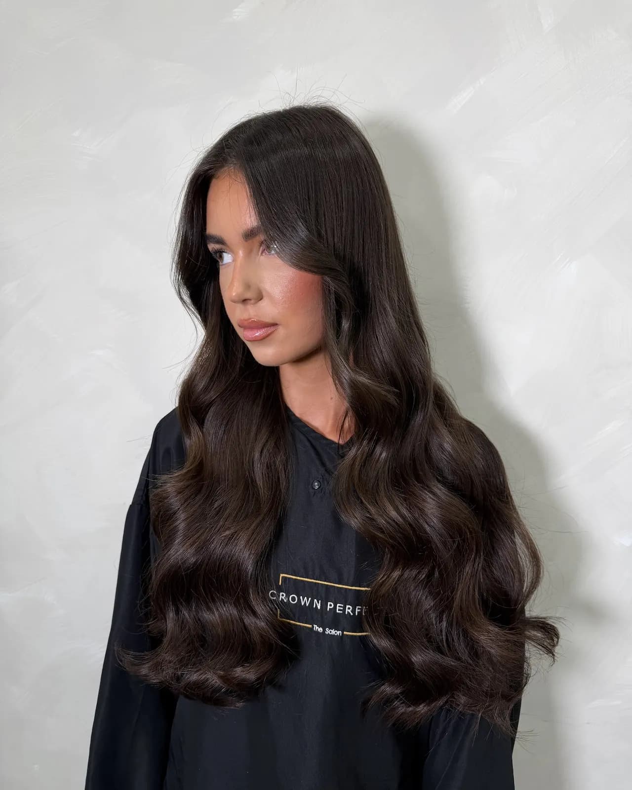 Side view of thick, long dark brunette hair extensions in soft waves, Crown Perfect, Surrey