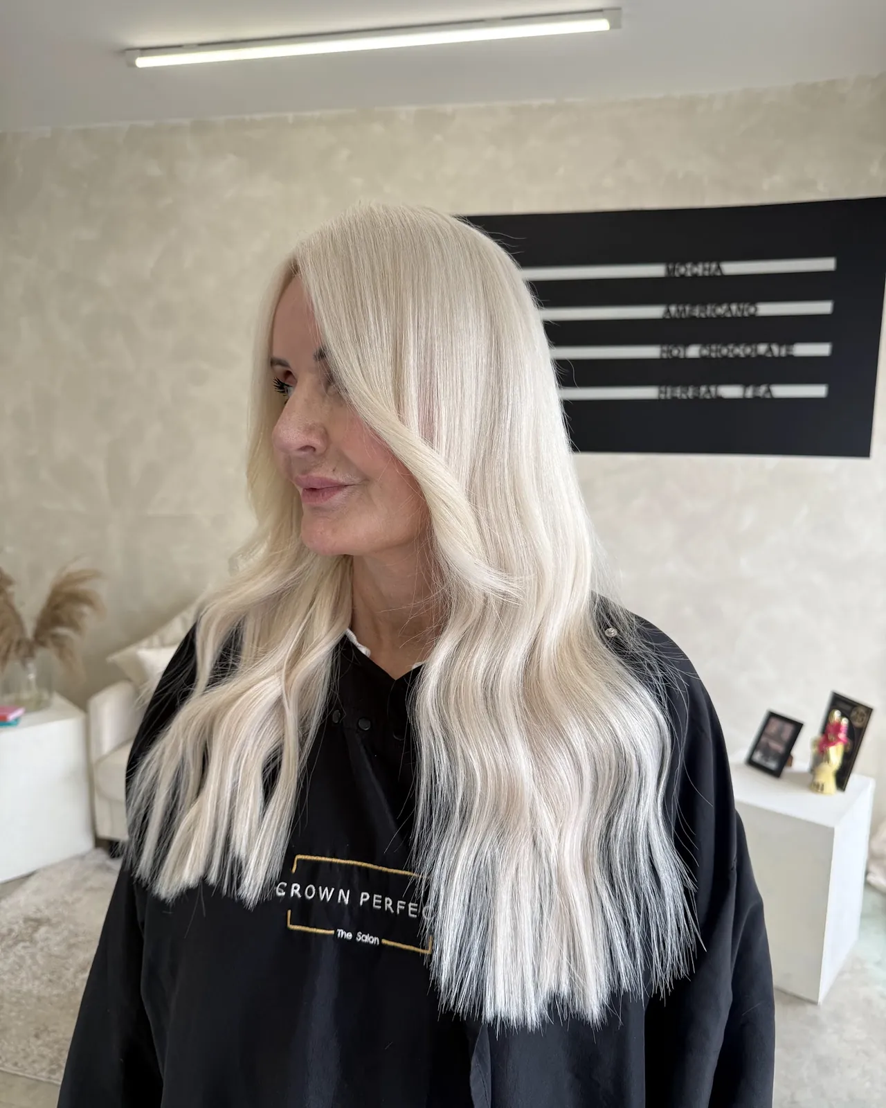 Platinum blonde hair extensions in glossy, styled waves, side view, Crown Perfect, Surrey