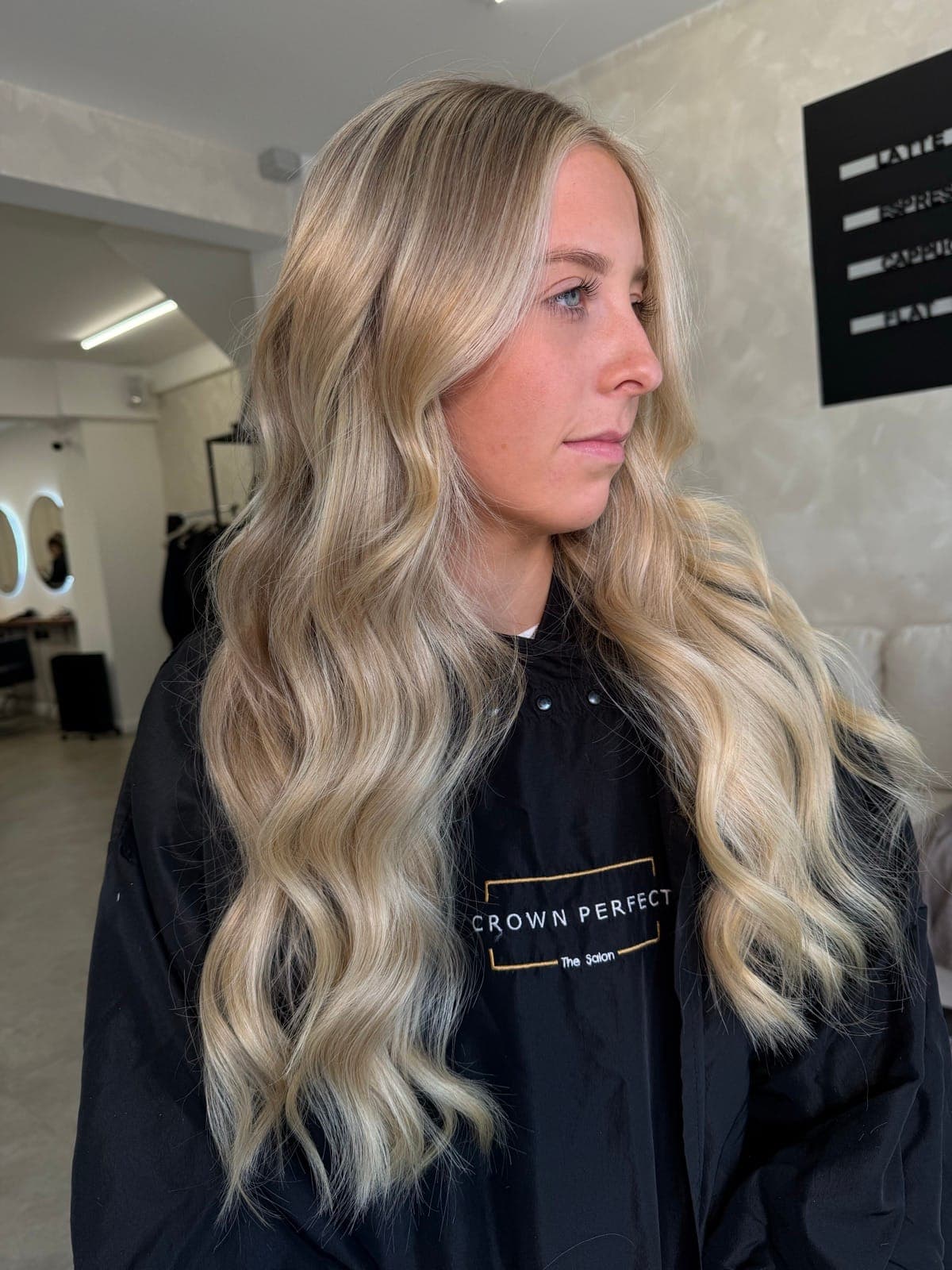 A grown-out blonde brightened into a cool, dimensional blonde with soft waves, after